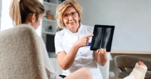 doctor showing a patient her broken bones on an X-ray